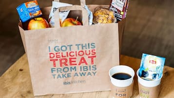 Una bolsa de papel con un mensaje, una taza de café y una bolsita de té.