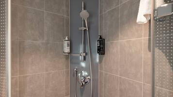 A modern shower with a handheld showerhead, a wall-mounted faucet, and a handheld shower attachment.