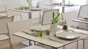 A clean, modern dining area with white tables, chairs, and minimalistic decor. - THE 8 Boutique B&B (Barcelona)