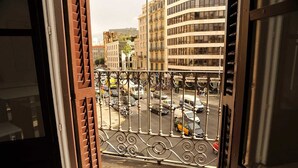 A view from a balcony with a wrought iron railing overlooking a busy street with cars and buildings. - THE 8 Boutique B&B (Barcelona)