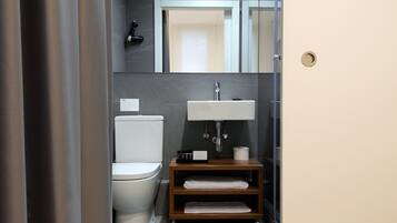 A modern bathroom with a toilet, sink, and mirror.