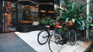 A hotel entrance with a modern design, a reception desk, and a bicycle parked outside. - CasaSur Bellini (Buenos Aires)