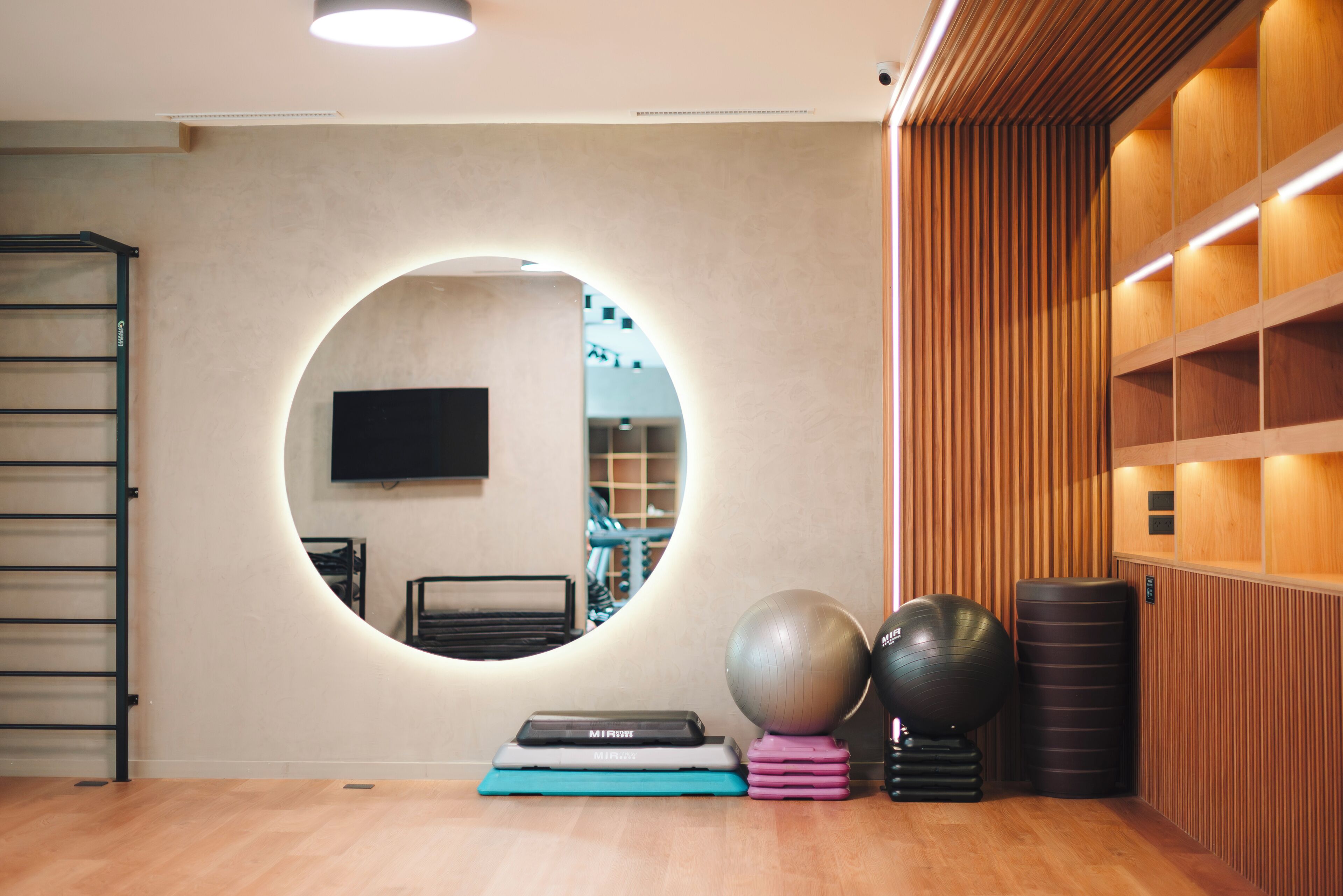 A gym with exercise equipment, a mirror, and wooden paneling.