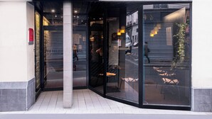 The exterior of Hotel Davail with a glass entrance, a visible outdoor seating area, and a clear view of the street. - Hôtel Daval (Paris)