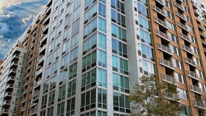 A high-rise building with multiple floors, large windows, and balconies. - Crystal Quarters Furnished Apartments- Concord (Arlington)