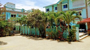 A courtyard with a paved area, surrounded by buildings with light blue facades and decorative elements.