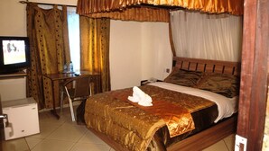 A hotel room with a bed, a desk, and a television.