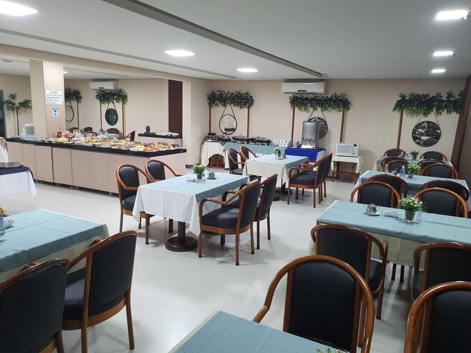 A dining area with multiple tables and chairs, a buffet counter, and ceiling fans.