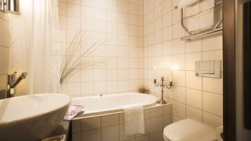 A bathroom with a freestanding bathtub, a sink, and a toilet.