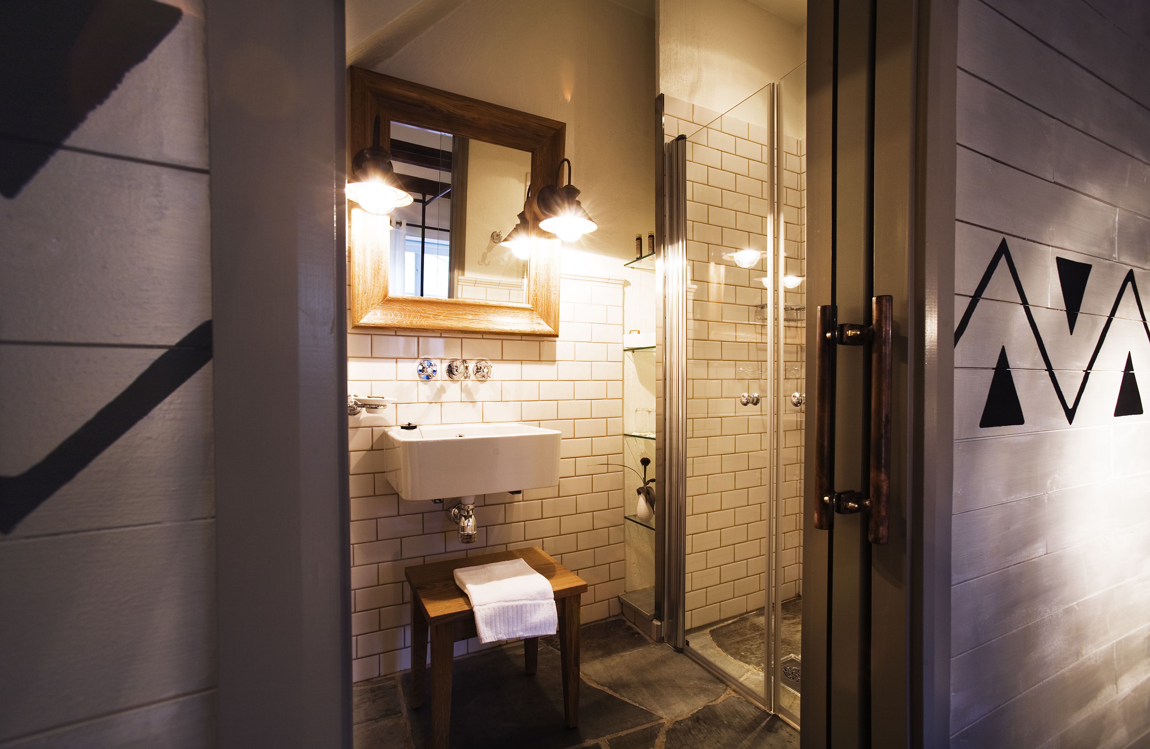 A modern bathroom with a sink, mirror, and shower.