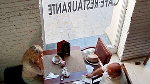 A cafe with a sign reading "CAFE-RESTAURANT" and a table with breakfast items. - Hotel Terranostra (Valparaiso)