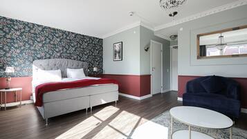 Un dormitorio con cama, mesita de noche, una silla y un espejo.