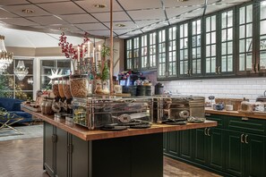 A kitchen with green cabinets, a wooden countertop, and a large window. - Hotell Arkad (Vasteras)