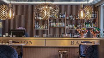 A bar area with a reception desk, wooden paneling, and hanging light fixtures.