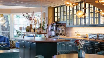 Una cocina moderna con armarios oscuros, una isla central e iluminación colgante.