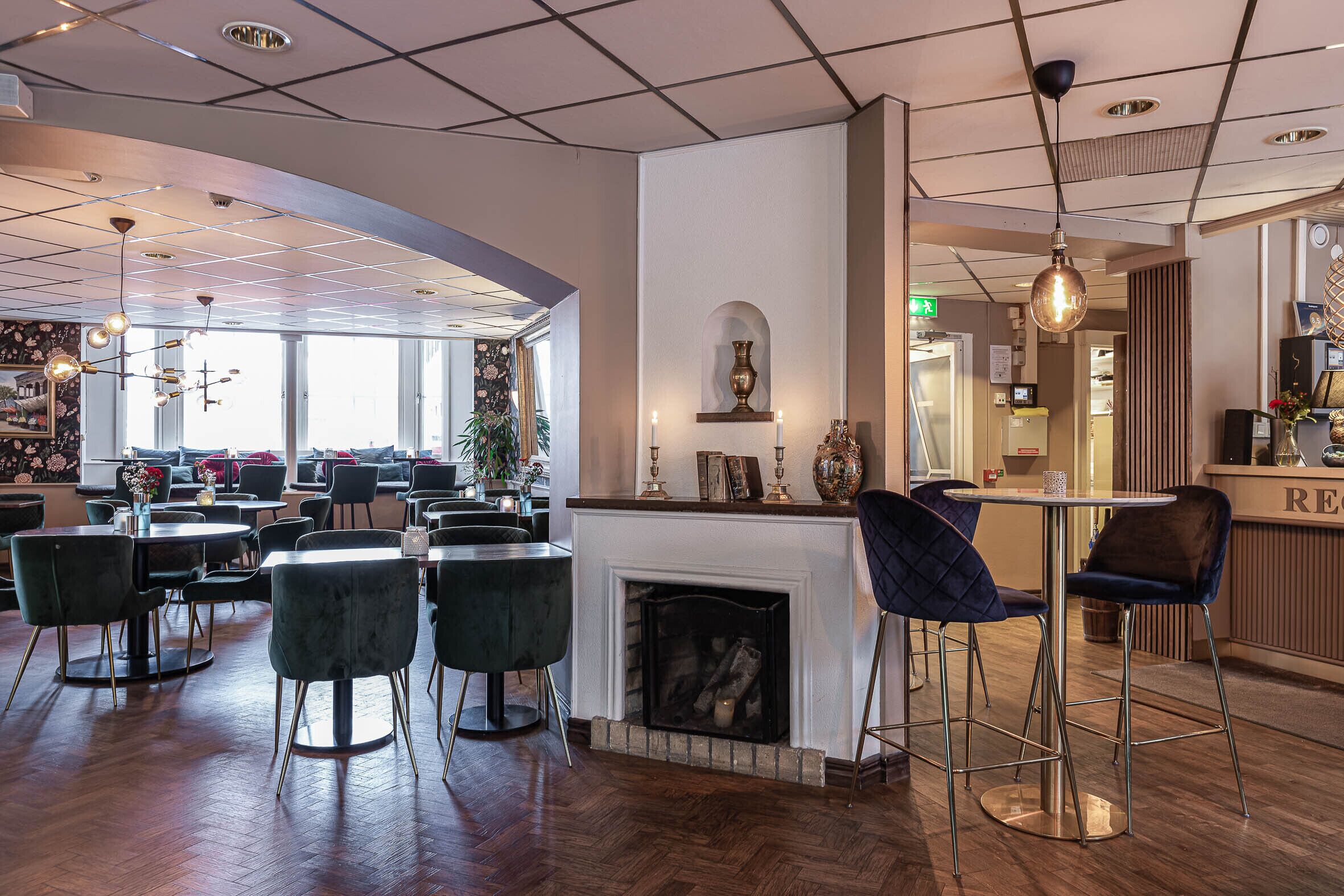 Um restaurante moderno com lareira, mesas redondas e bancada no bar.