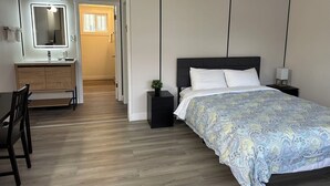 A bedroom with a bed, bedside table, nightstand, and a desk with a mirror and vanity. - Hope City Centre Motel (Hope)