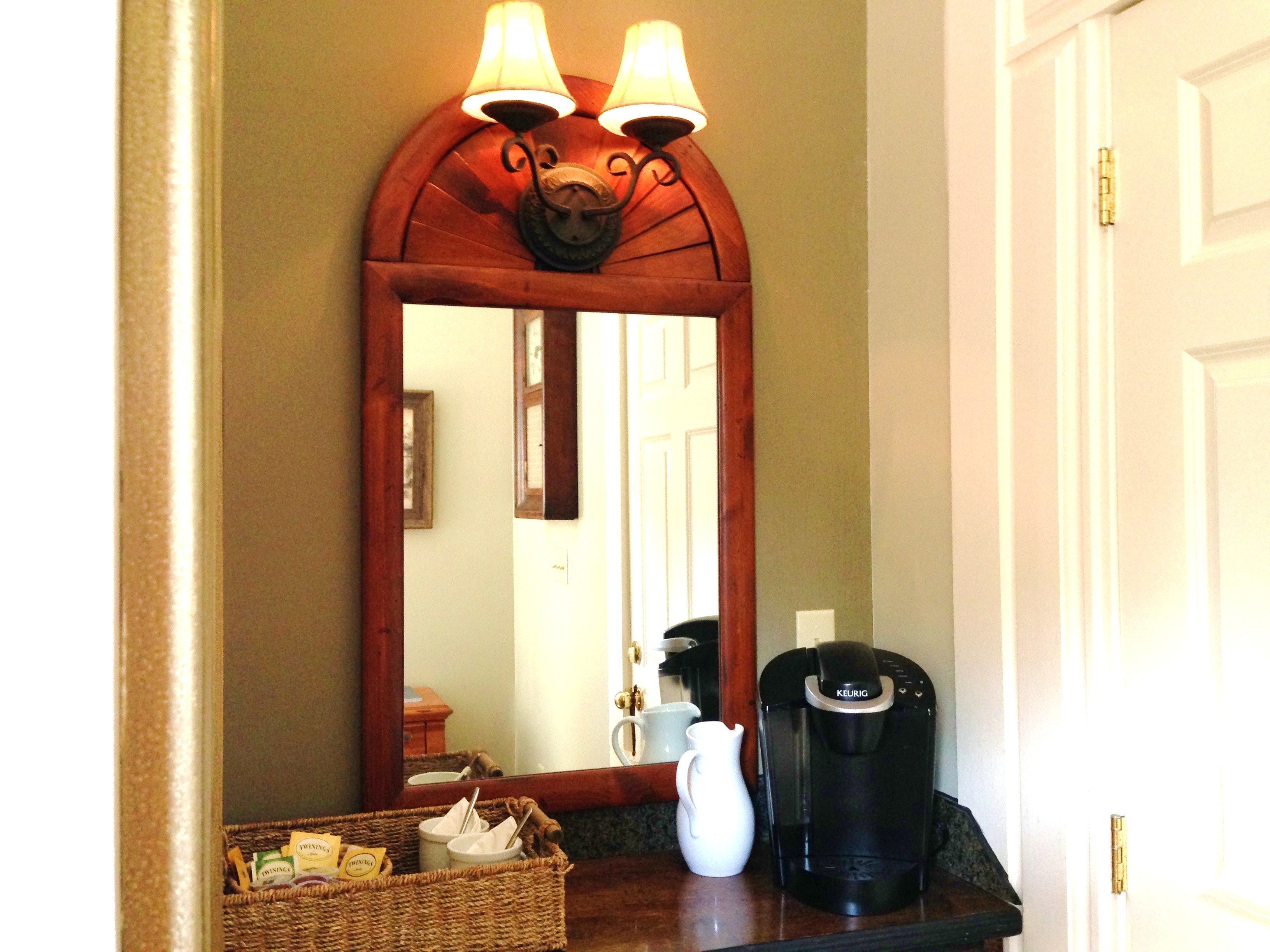 Un bany amb mirall, una cafetera i un cistell de productes de tocador.