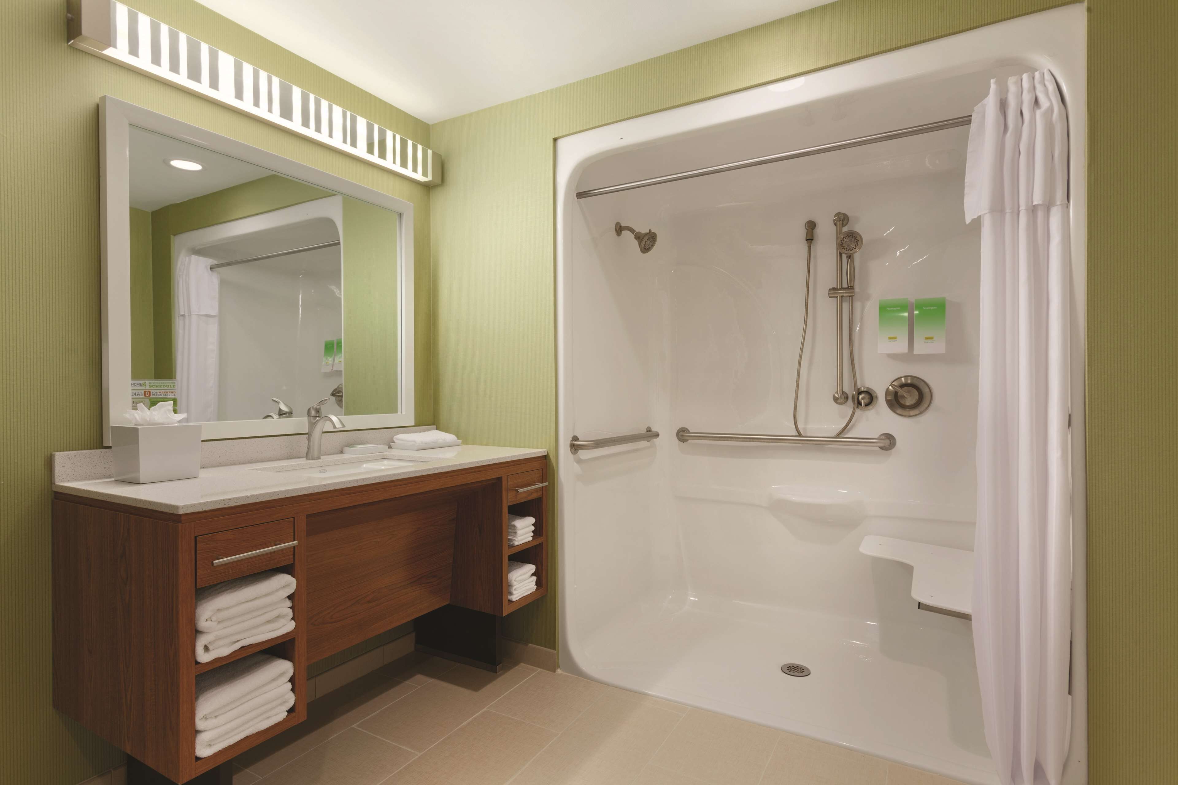 Une salle de bain avec une douche, un lavabo et un miroir.