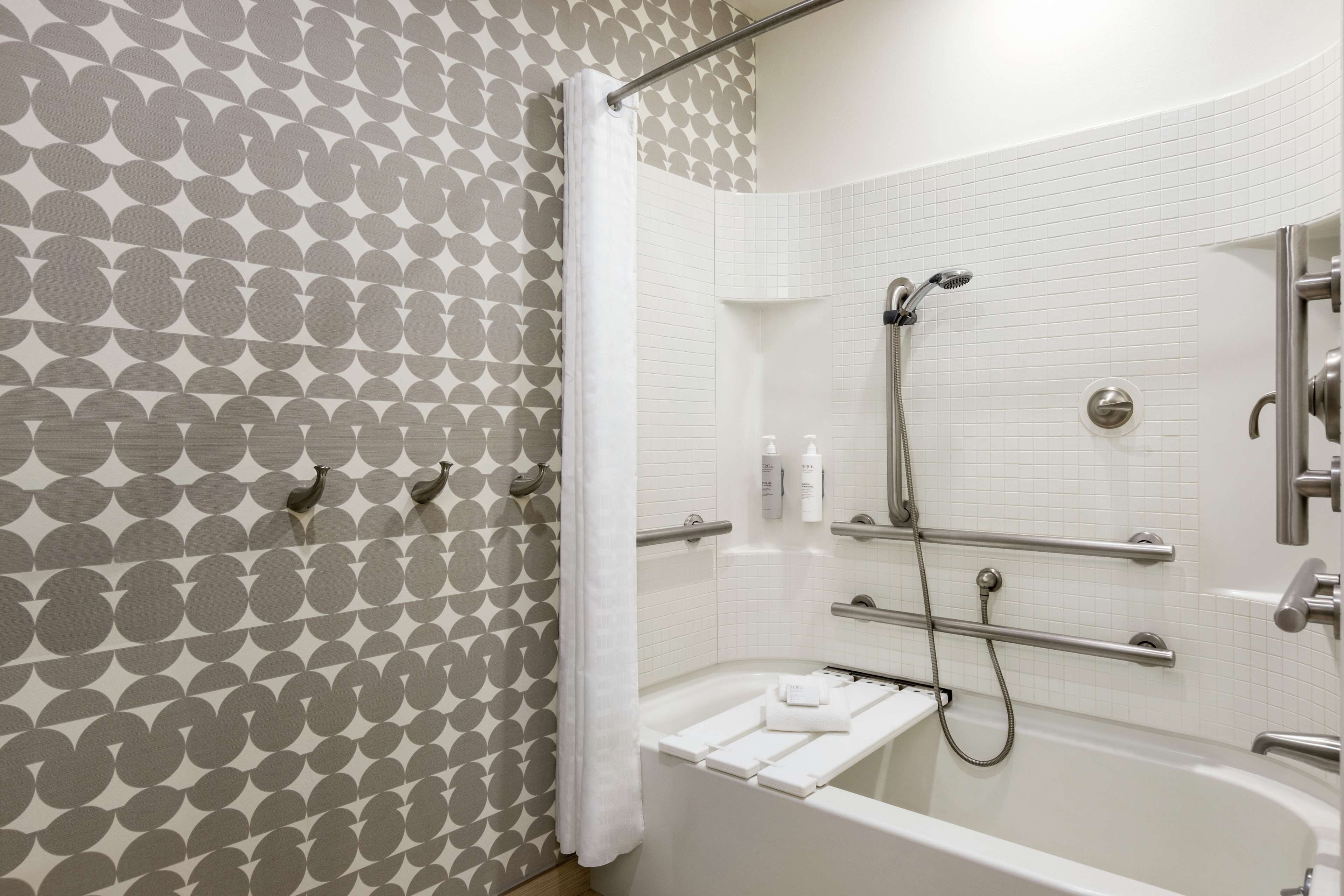 A modern bathroom with a shower, a bathtub, and a towel rack.