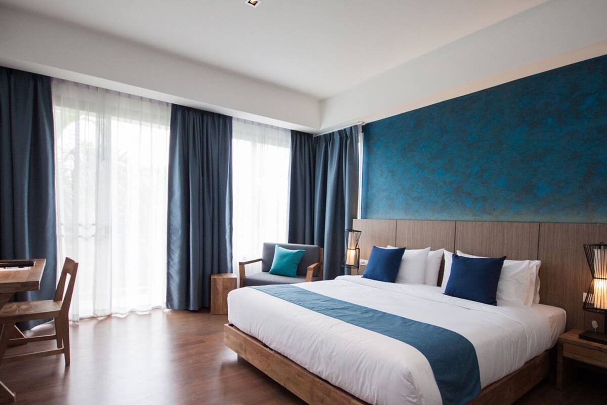 Ein modernes Hotelzimmer mit einem großen Bett, einem Schreibtisch und einem Stuhl.