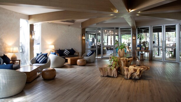 A spacious living area with wooden beams, comfortable seating, and large windows offering views of the outdoors. - The Leela Resort & Spa Pattaya (Pattaya)