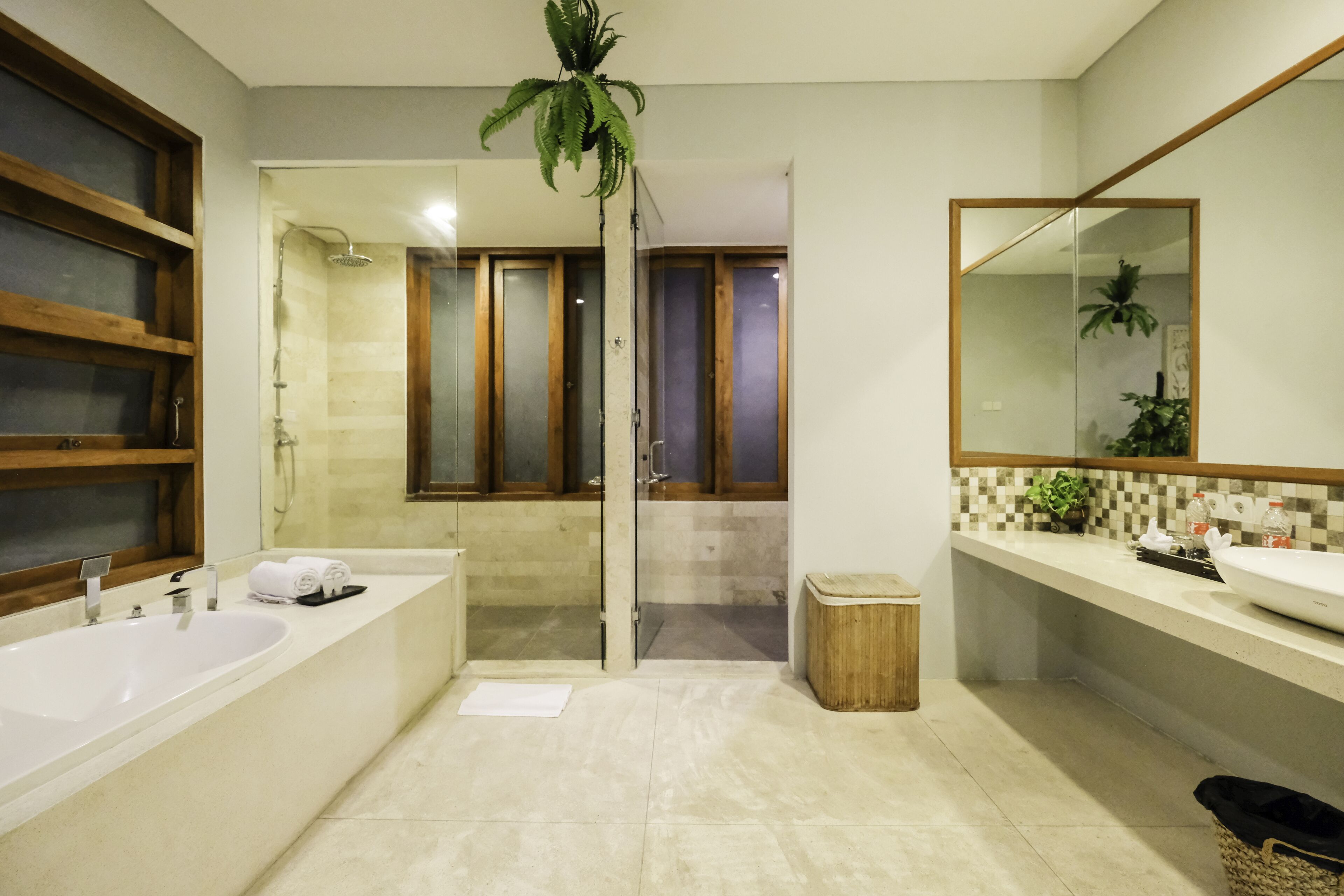 A modern bathroom with a large bathtub, a shower area, and a vanity with a mirror.
