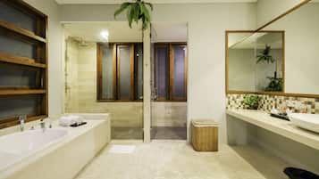 A modern bathroom with a large bathtub, a shower area, and a vanity with a mirror.