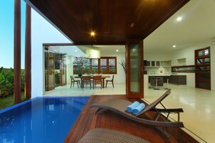 Uma casa moderna com piscina, área de refeições e cozinha.