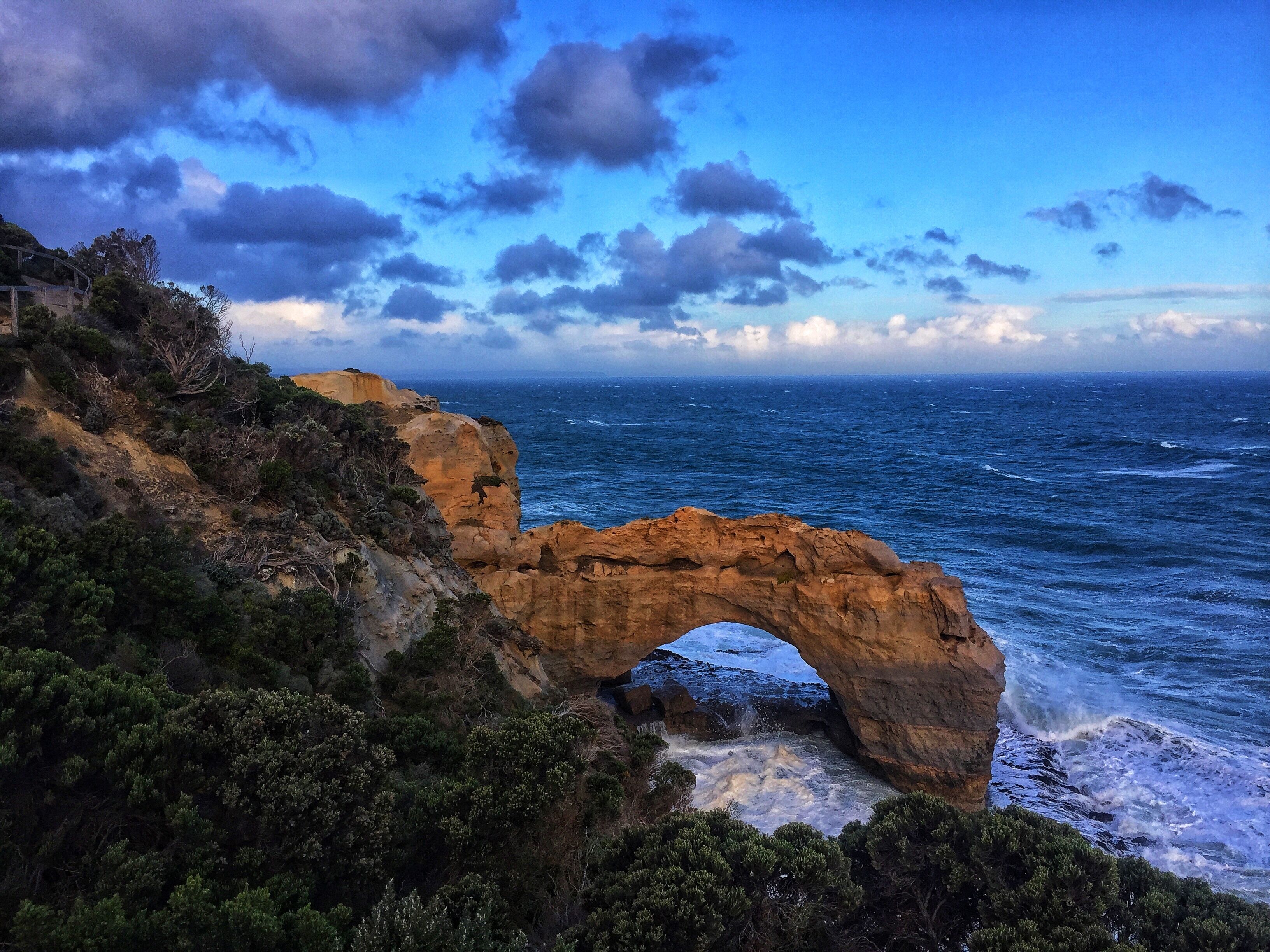A coastal landscape with a natural rock arch formation.