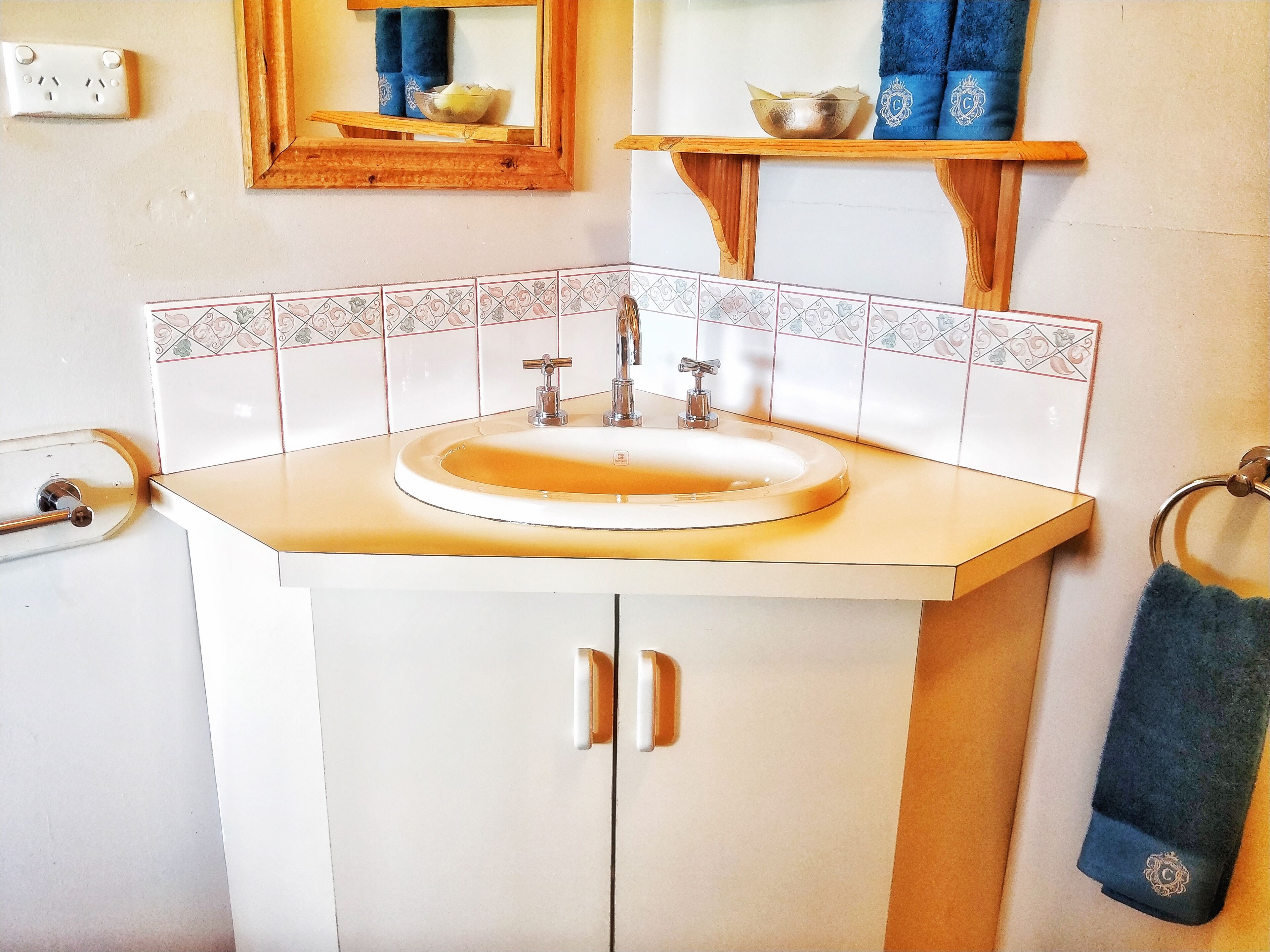 A bathroom with a sink, mirror, and towel rack.