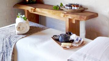 Relax in our serene spa area, featuring a wooden bench and a table with a soothing atmosphere.