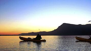 Un lac paisible au coucher du soleil, avec deux kayaks.