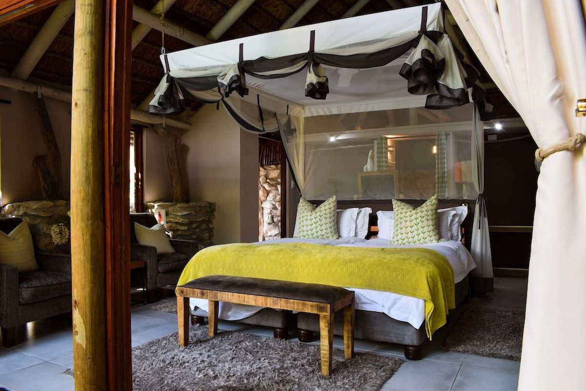 A bedroom with a bed, bedside table, and a canopy.