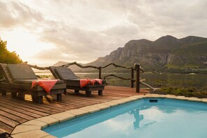 Alberca al aire libre y camastros 