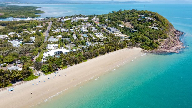 An aerial view of a coastal resort with a sandy beach, dense greenery, and a clear blue sea. - Silkari Reflections of Port Douglas (Port Douglas)