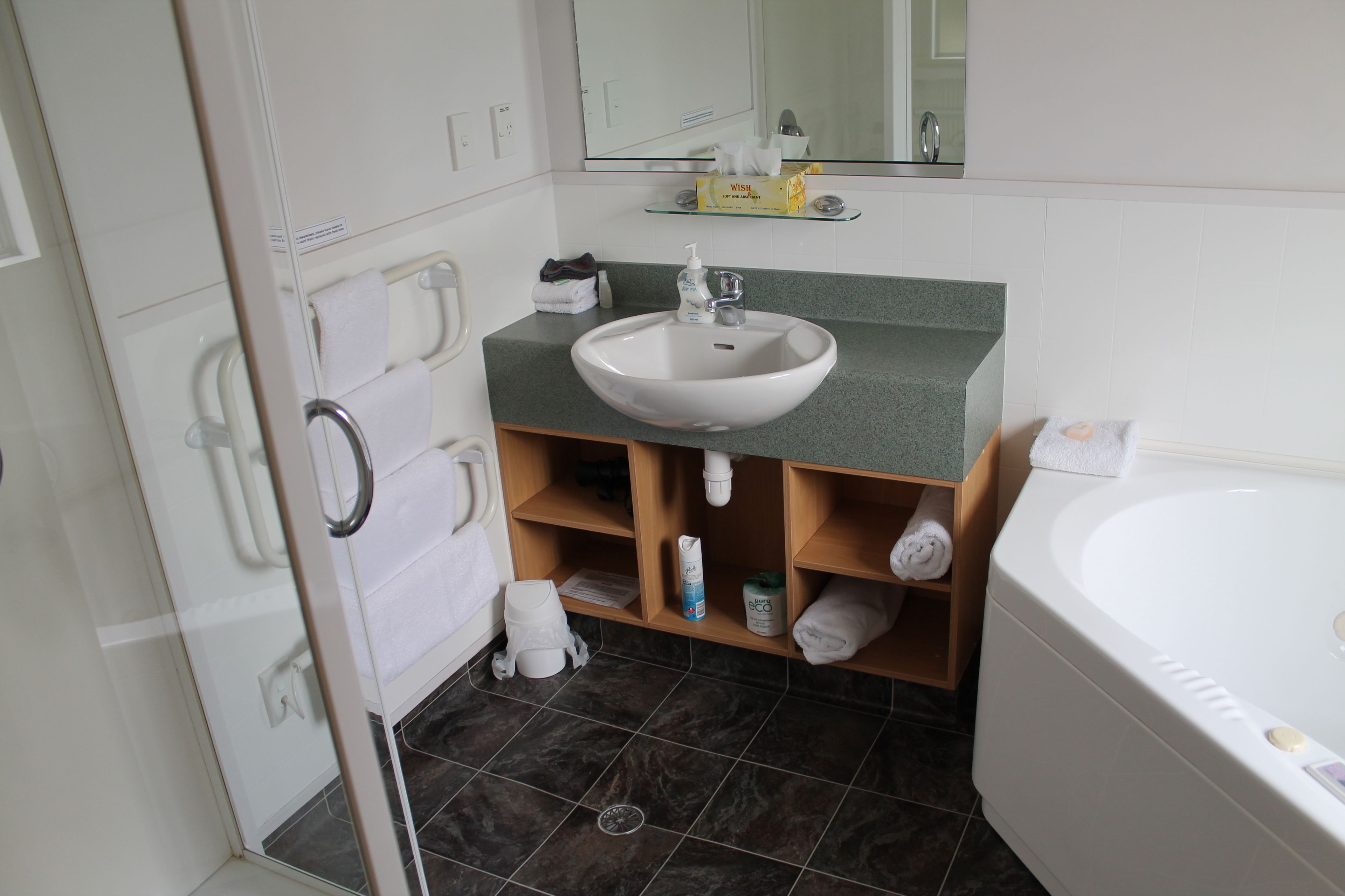 A bathroom with a white sink, a mirror, a shower, and a bathtub.