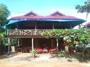 A two-story wooden building with a red roof and a covered outdoor seating area with red umbrellas. - Otres Beach Resort (Sihanoukville)