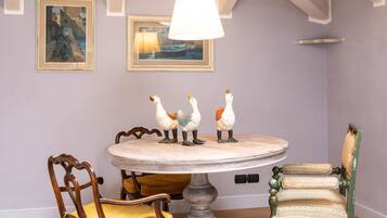 Comedor con una mesa redonda, dos sillas y tres figuritas decorativas de cisnes.