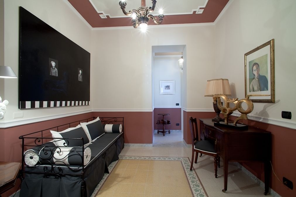 Una habitación con cama, escritorio, silla, lámpara y un cuadro en la pared.