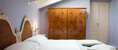 Un dormitorio con una cama grande, un armario de madera y una puerta blanca.