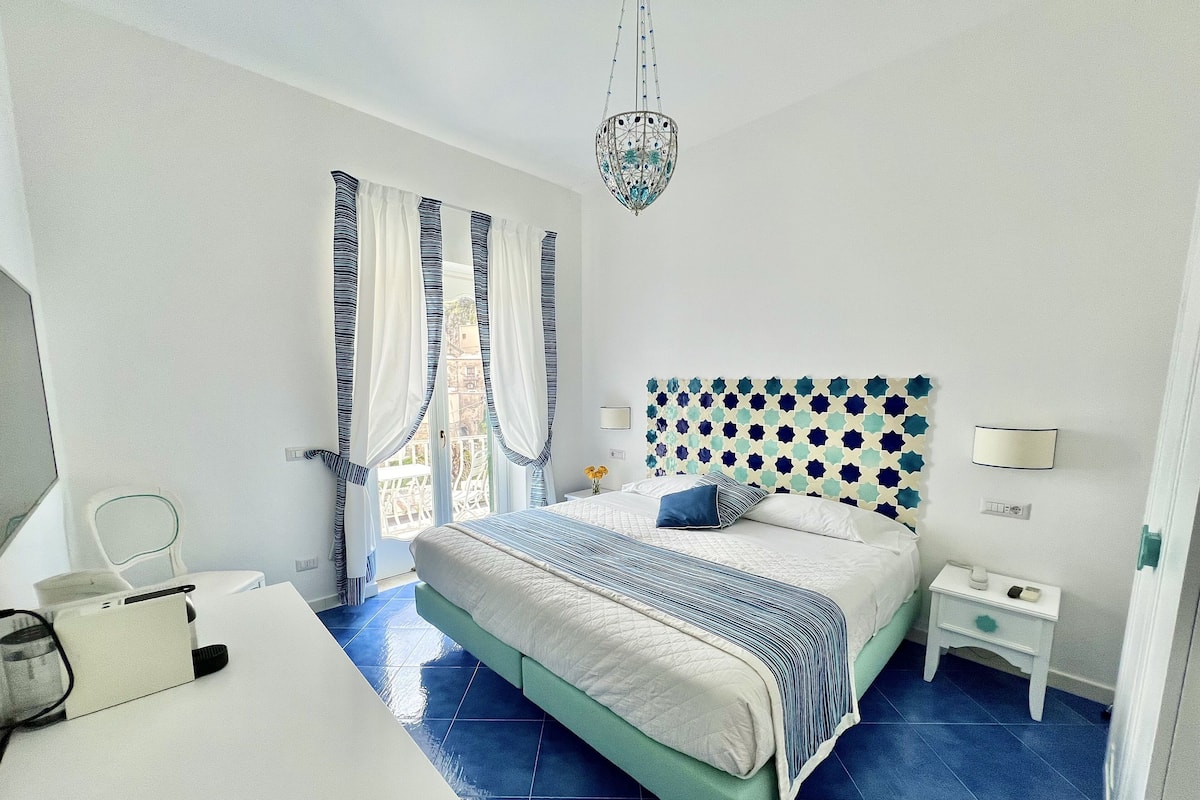 Une chambre à coucher comprenant un lit, une table de chevet et un bureau avec une chaise.