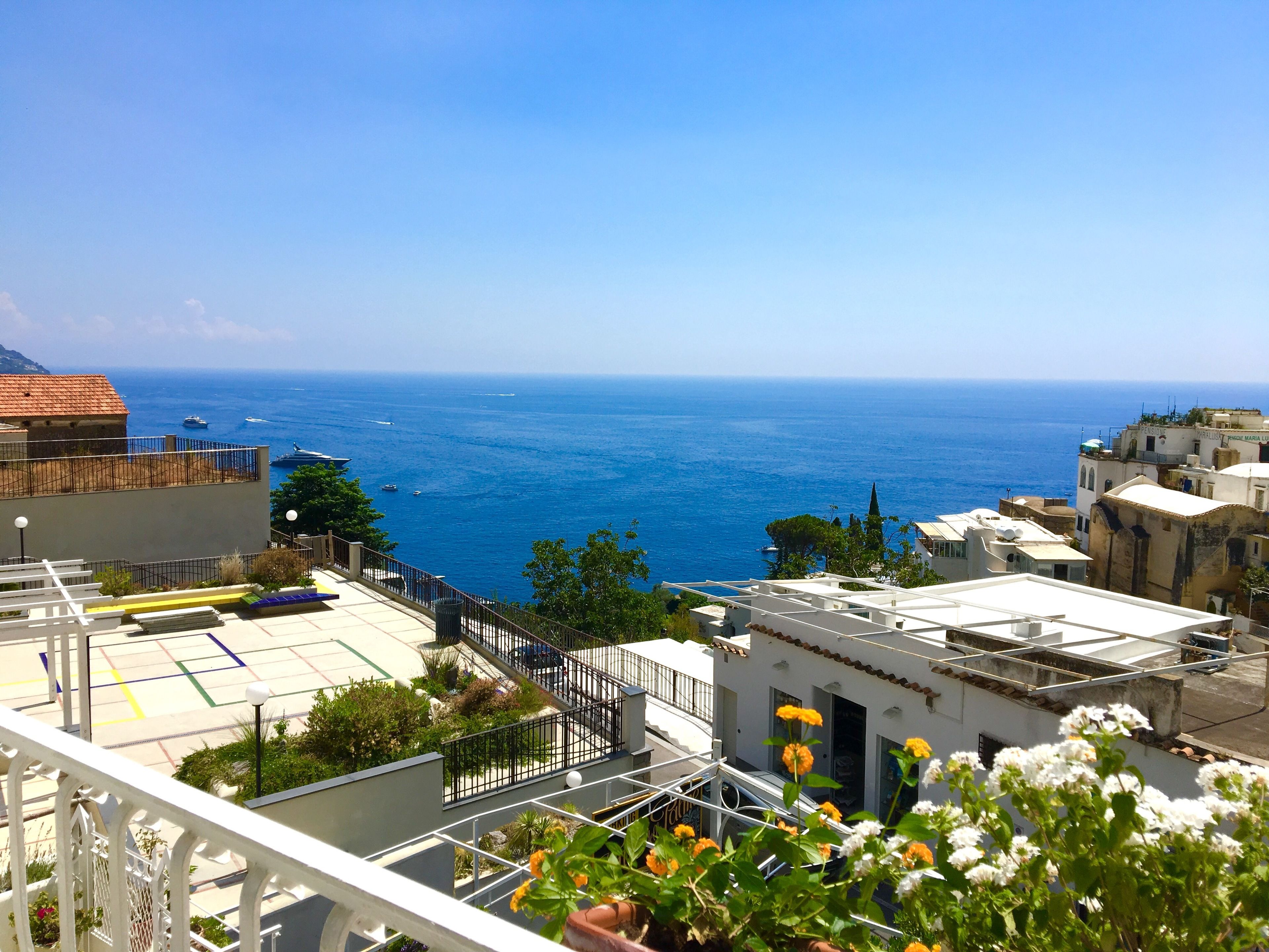 A coastal view with buildings, a clear sky, and the sea.