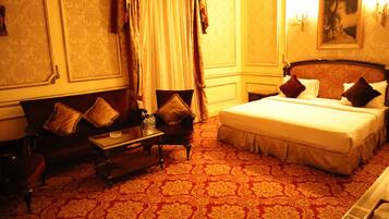 Una habitación de hotel con una cama grande, un sofá, una mesita y una silla.