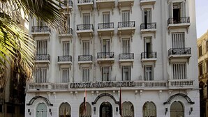 A multi-story Windsor Palace Hotel with a classic architectural style, featuring balconies with wrought iron railings and a symmetrical facade.