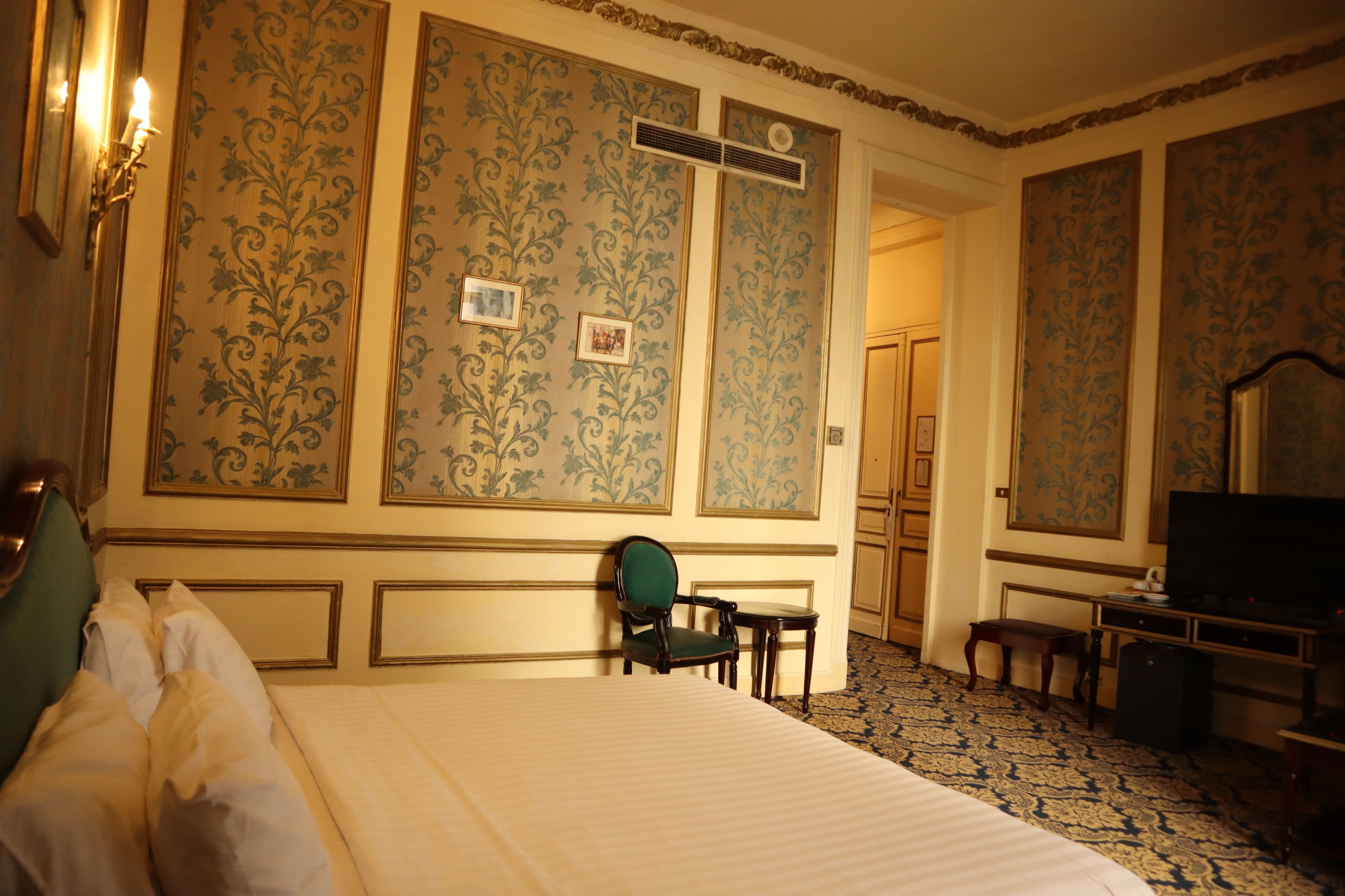 Una camera d'albergo con un letto grande, una scrivania, una sedia e un televisore.