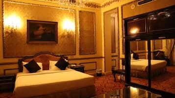 Une chambre d’hôtel avec un grand lit, une table de chevet, un miroir et un lustre.