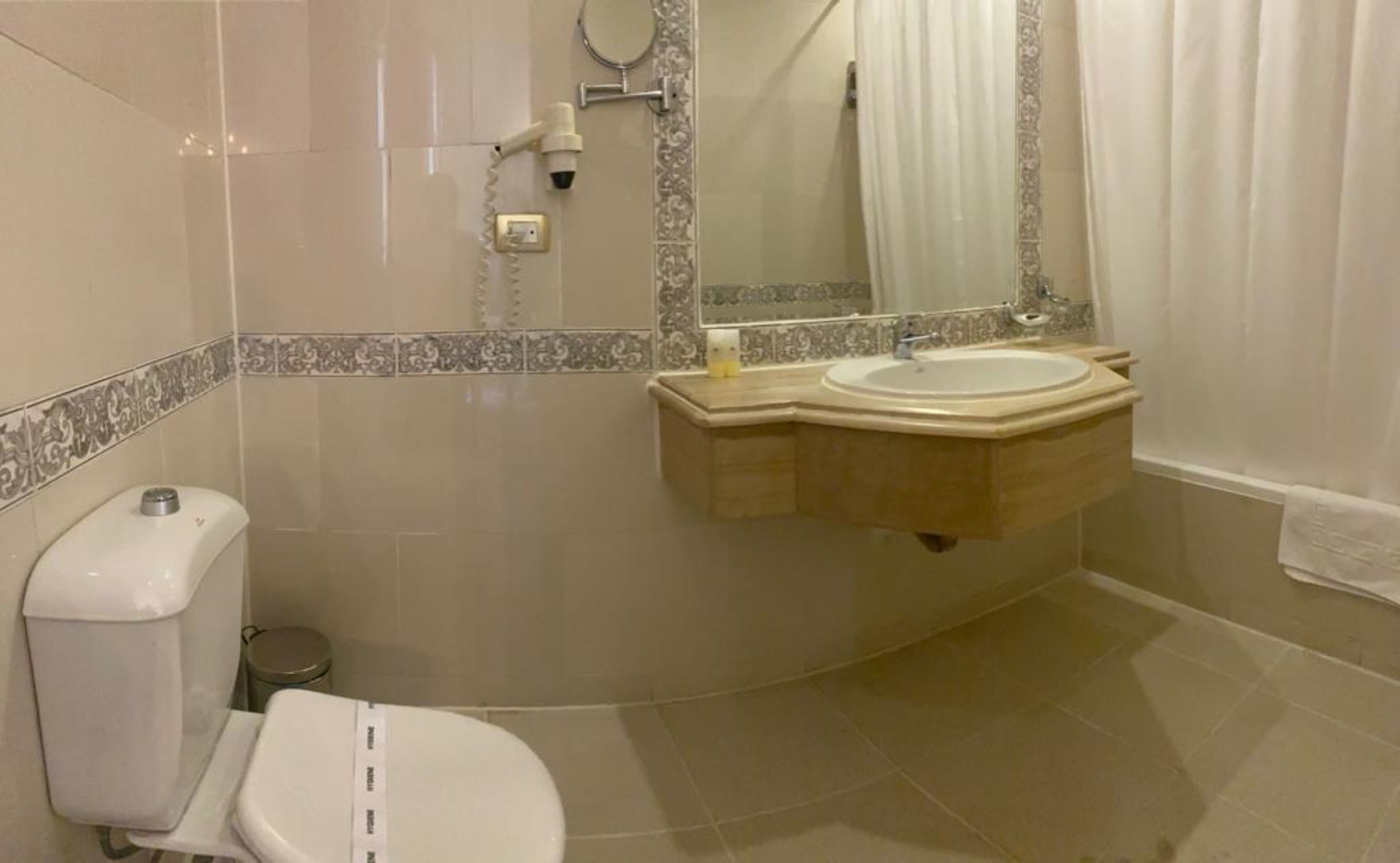 Un baño con inodoro, lavamanos y espejo.