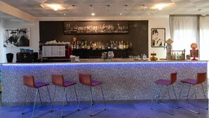 A bar area with a patterned counter, bar stools, and a cityscape artwork on the wall. - Hotel Etna (Riccione)