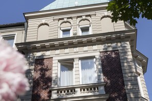 A building with a classical architectural style, featuring a prominent central section with arched windows and a balcony. - Parkhotel Traunstein (Traunstein)